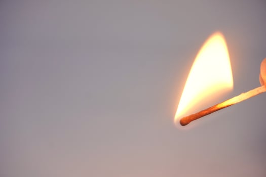 Burning matchstick with bright flame close-up photo