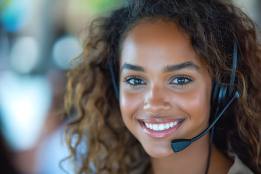 Smiling young woman with curly hair wearing a headset, providing customer service in a bright, modern setting. photo