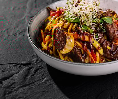Asian beef stir fry with noodles and vegetables closeup photo