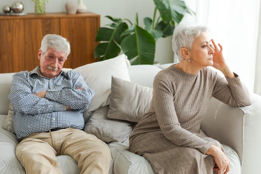 Marriage crisis relationship problems. Old couple quarreling. Sad mature disappointed woman sitting away from husband after having quarrel. Senior couple not talking having problems in relationship photo