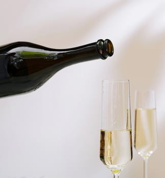 Pouring sparkling wine into elegant flute glasses photo