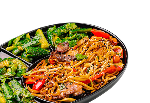 Delicious stir-fried noodles served with vegetables on a platter photo