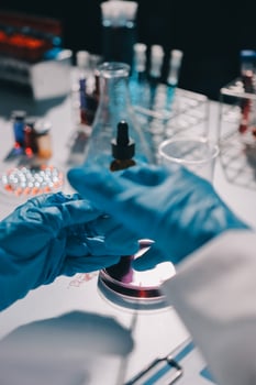 A person in a lab coat is holding a test tube photo