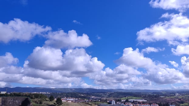Stunning panoramic view of a picturesque landscape under a vibrant blue sky adorned with fluffy cumulus clouds. photo