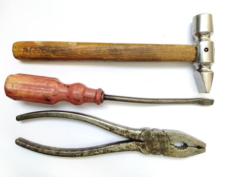 Vintage tools hammer, screwdriver, pliers. A classic still life showcasing aged craftsmanship. Perfect for DIY, repair, construction, or retro themes. Evokes feelings of nostalgia and hard work. photo