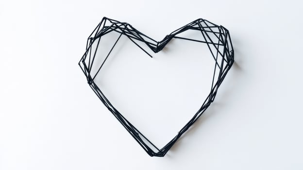 Geometric black wire heart shaped wall art on white background photo