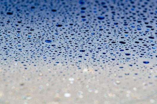 Water droplets on a dark blue ocean color background with customizable space for text or ideas photo