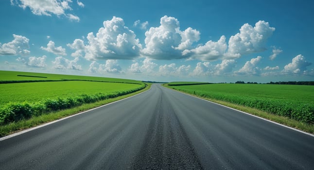 Asphalt Road Through Green Fields on a Sunny Day photo