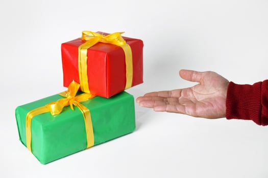 A Warm Hand Offering a Holiday-Themed Gift Box photo