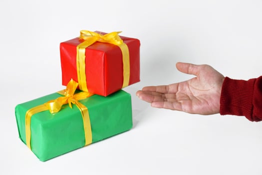 A Hand in a Red Sweater Presents a Festive Gift Box photo