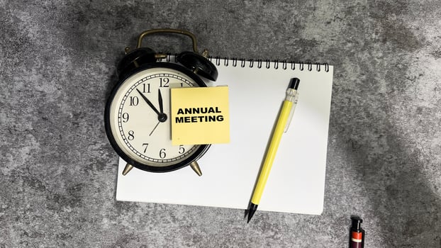 Concept of Annual Meeting write on sticky notes isolated on Wooden Table. photo
