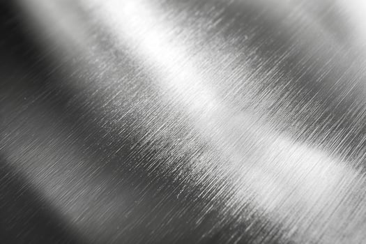 Close-up of brushed metal texture, highlighting smooth lines and reflective surfaces. photo
