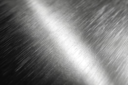 Close-up of polished stainless steel with reflective surface textures and subtle light streaks. photo