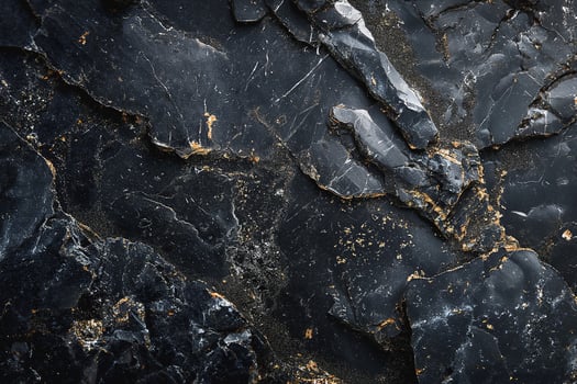 Close-up of a textured black slate surface with gold veins and intricate patterns. photo