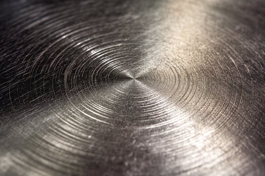 A close-up view of a polished metal surface exhibiting circular patterns. photo