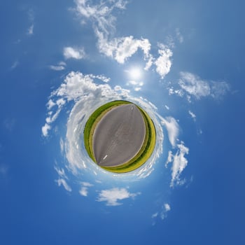 A small planet with a road and sky photo