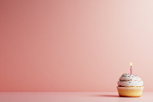 A cupcake with frosting and a candle on a pink background. photo
