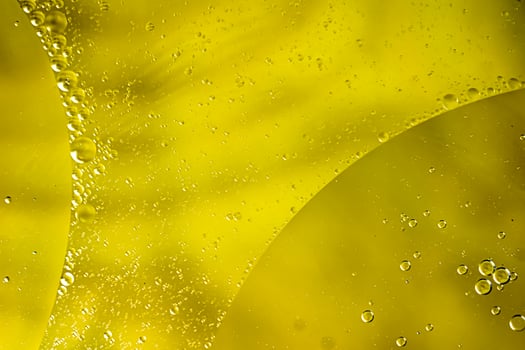 oil drops on water on yellow background photo