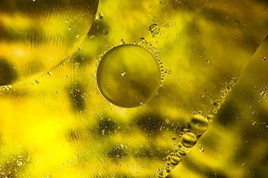 oil drops on water on yellow photo