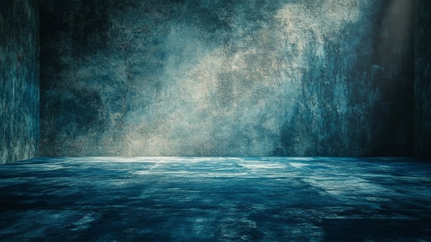 A moody, dark room with textured walls in shades of blue and teal, illuminated by a single light source. The floor adds to the visual texture. photo
