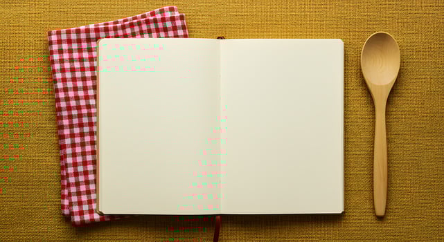 Blank notebook, spoon and red gingham napkin on yellow background photo