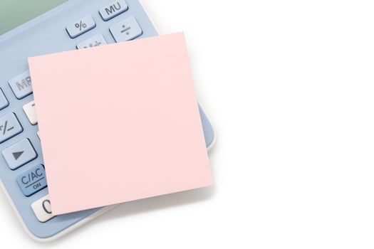 Blank Pink Sticky note with calculator background. Financial data analyzing. Copy space for text on sticky note. isolated on white background. photo