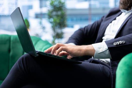 Motivated young leader working in a luxurious urban workspace, reviewing financial forecasts and tracking sales performance. Chief executive officer browses laptop in his office. Close up. photo