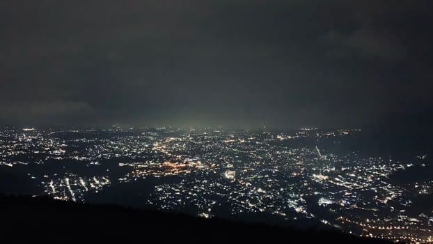 Nighttime Cityscape with Illuminated Lights. Paralayang Batu Malang, Indonesia photo
