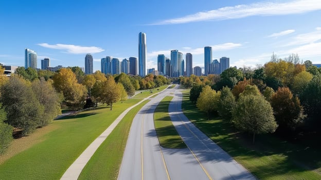 A city skyline with trees and a road photo