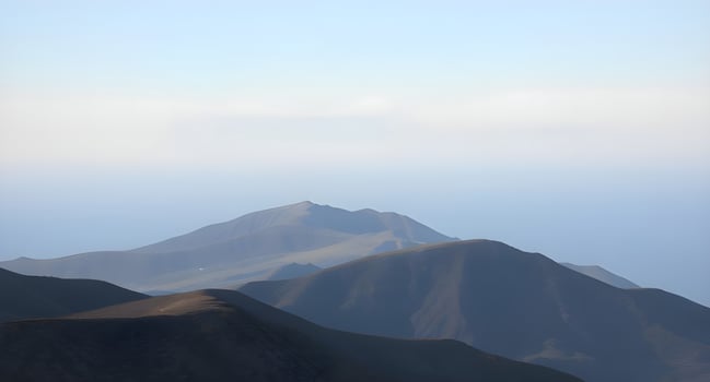 A mountain range with a plane flying over it photo