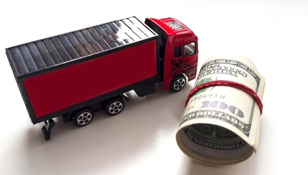 A red toy truck, rolls of US currency photo
