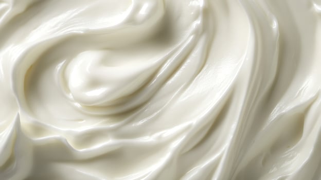 A close-up showcases the rich, creamy texture of a smooth, white substance, swirled and glossy, creating an inviting visual texture. photo