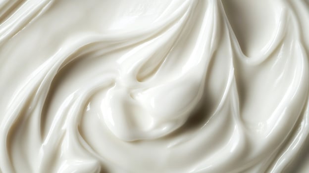 Close-up of swirls of smooth, white cream. The texture is rich and glossy, creating a sense of luxurious skincare and beauty products. photo