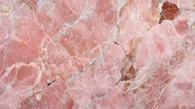 Detailed view of a rose colored stone slab with white veins running throughout, creating a natural and unique patterned surface. photo