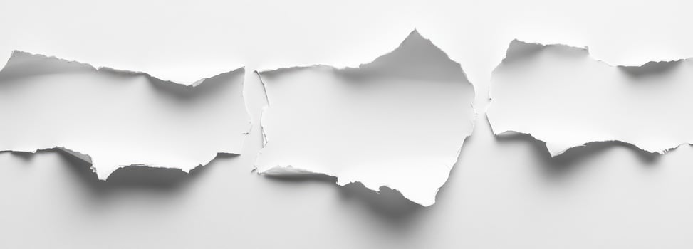 Three Torn Pieces of White Paper on a White Background photo
