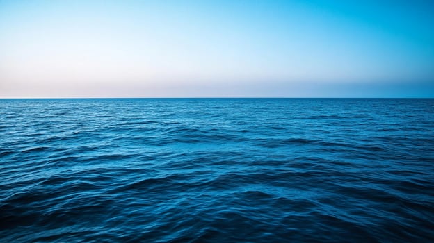 An endless expanse of blue ocean water meets a serene sky, creating a peaceful and calming seascape perfect for relaxation or inspiration. photo