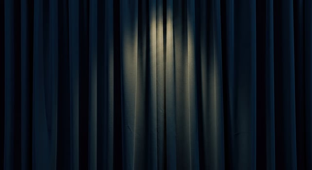 A dark curtain with a light shining through it photo