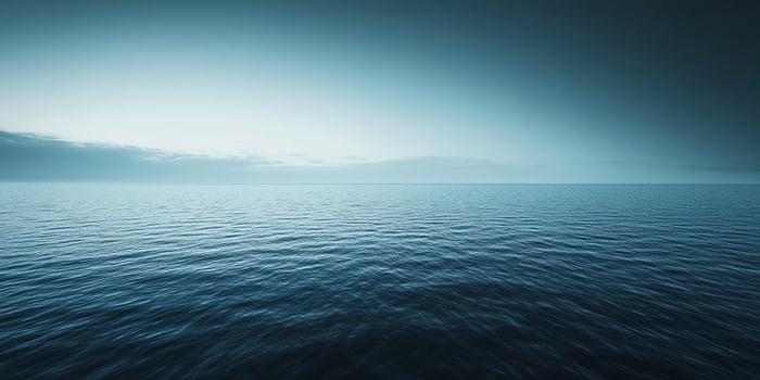 Vast, serene ocean stretching to the horizon with gentle ripples reflecting the soft light of the sky above. Calming and peaceful scene. photo
