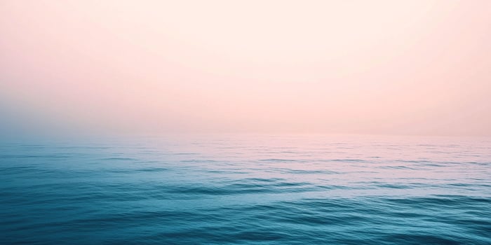 Vast expanse of blue ocean meeting a soft pink sky, creating a serene horizon. A peaceful seascape conveying tranquility and calm. photo