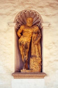 Statue of Hercules - mythological strongman, mythical male figure, in a niche, wall around photo