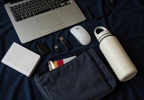Flat lay composition with laptop, mobile phone, notebook and other objects on black fabric. Work essentials photo