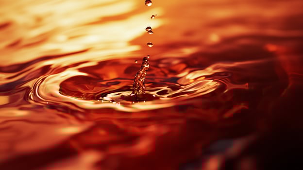 A captivating image showcasing the rippling warm tones of water as a droplet creates a splash, highlighting the beauty of fluid dynamics and the mesmerizing patterns formed. photo