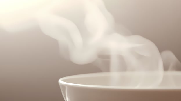 Hot steam rising from white cup of coffee or tea photo