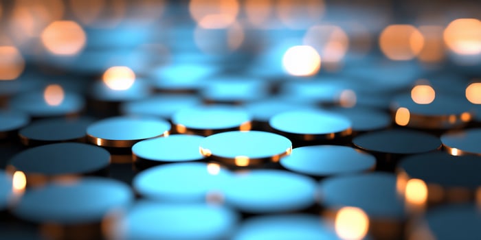 A close-up of reflective, circular surfaces with a soft blue glow. photo