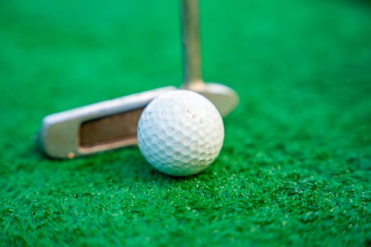 Mini-golf clubs and balls on artificial grass. Family vacations or resort. . High quality photo