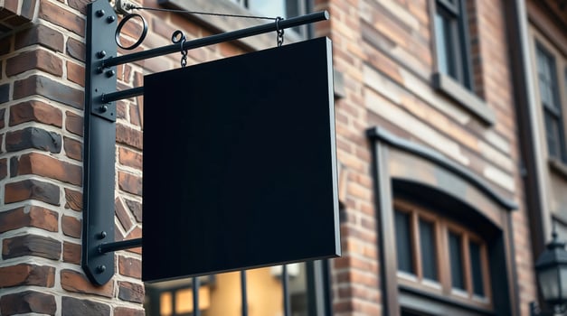 A black sign hanging on a brick building photo