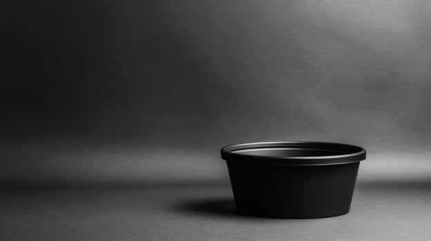 Simple black pot on a dark background with soft lighting photo