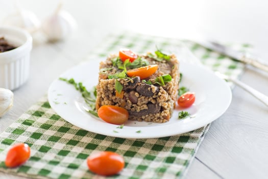 Delicious breakfast.boiled bulgur in a plate with cherry tomatoes photo