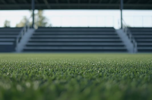 A panoramic view of a football field with bright green turf and white boundary lines. The wide-open space is perfect for sports-themed visuals, teamwork concepts, and dynamic action shots photo
