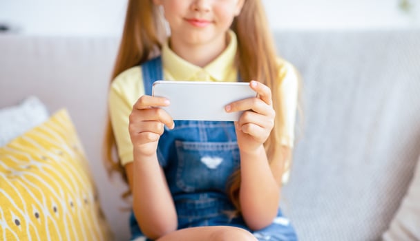 Closeup portrait of girl holding her cell phone, playing games online, selective focus on device photo